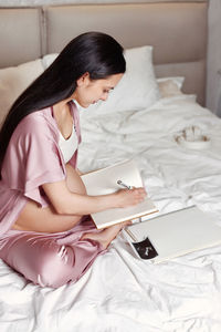 High angle view of woman lying on bed at home