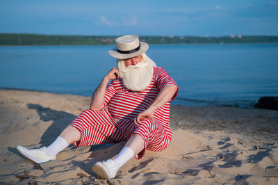 Full length of woman sitting on beach