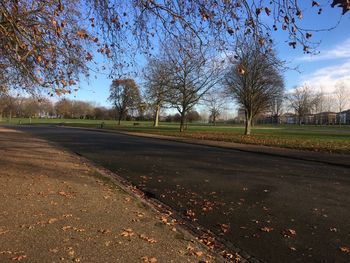 Empty road amidst field against sky during autumn