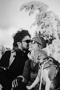 Low angle view of a couple and a dog standing on snow