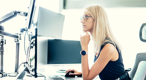 Portrait of young woman using mobile phone while sitting at home