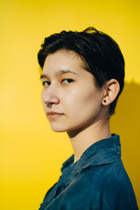 Portrait of young man against yellow background