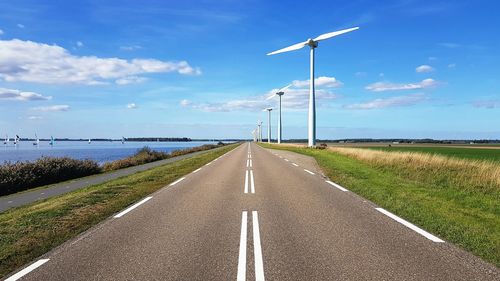 Road amidst green landscape against sky