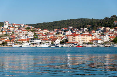 Scenic view of a village across sea against clear sky