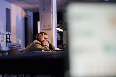 Portrait of woman using mobile phone while sitting in office