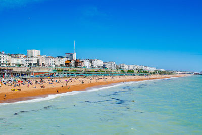 View of beach and buildings against blue sky