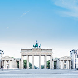 Street by brandenburg gate against sky