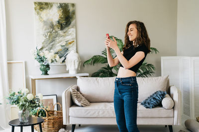 Beautiful young woman dancing at home alone in headphones.