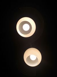 Low angle view of illuminated lamp in darkroom