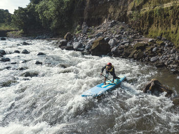 Man paddle boarding the river