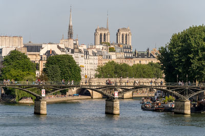 Bridge over river in city against buildings