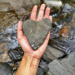 Close-up of hand holding heart shape rock