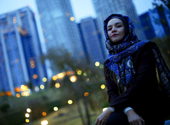 Young woman looking away in city during winter