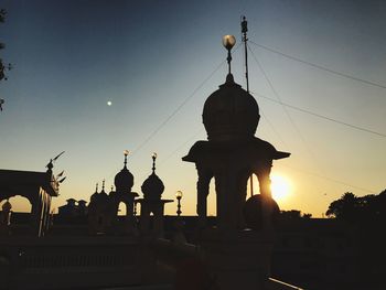 Silhouette statue against sky during sunset