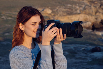 Portrait of woman photographing with camera