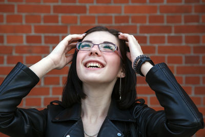 Portrait of young beautiful brunette smiling girl near brick wall. closeup outdoor