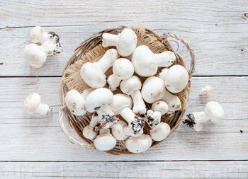 High angle view of white mushrooms on wooden table