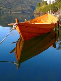 Close-up of sailboats moored on lake against sky