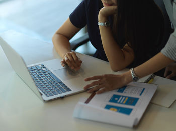 Midsection of businesswomen brainstorming in office