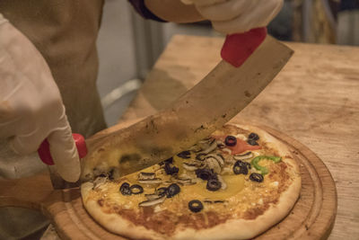 Human hand holding pizza