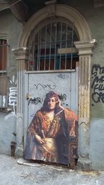 Portrait of young woman sitting outside building