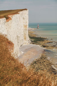 Sea by cliff against sky