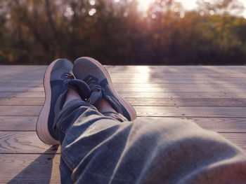 Low section of person relaxing on wooden plank