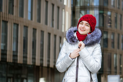 Woman in a warm jacket on the street near the building