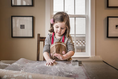 Cute girl making christmas cookie at home