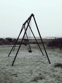 Metallic structure on field against clear sky