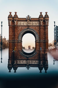Digital composite image of arc de triomf reflecting on water