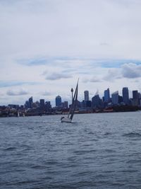 Sea by cityscape against sky