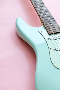 Close-up of guitar against pink background