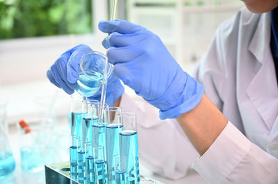 Midsection of scientist holding test tube