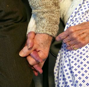 Midsection of old couple holding hands