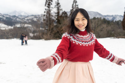 Portrait of smiling woman on snow covered land