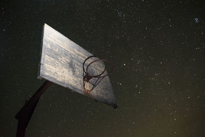 Low angle view of basketball hoop against star field in sky at night