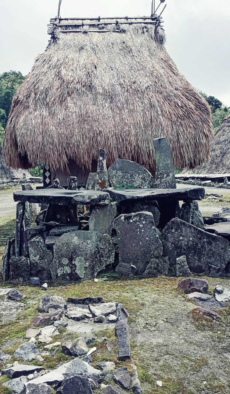 thatched roof, roof, hut, architecture, nature, thatching, built structure, rock, sky, no people, day, land, water, sea, building, outdoors, landscape, building exterior, house, environment, ruins, rural scene, cloud, plant, rural area