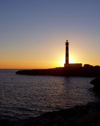 Silhouette lighthouse against clear sky