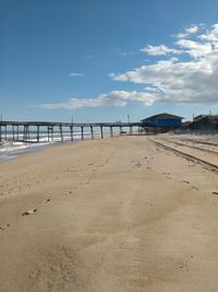 Pier on beach against sky