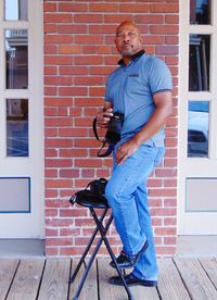 Portrait of man standing against brick wall