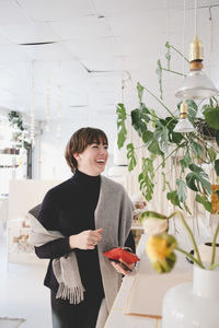 Cheerful female customer standing in upholstery shop