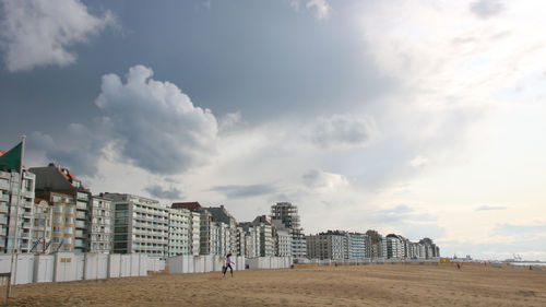 Buildings in city against cloudy sky