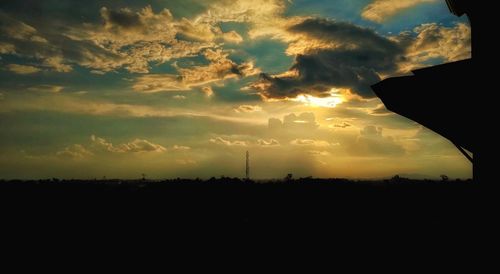 Scenic view of dramatic sky over silhouette landscape