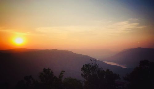 Scenic view of silhouette mountains against sky at sunset