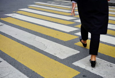 Low section of person walking on road