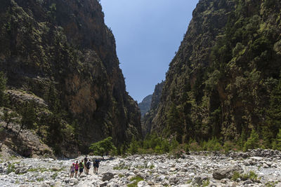 People hiking against mountains