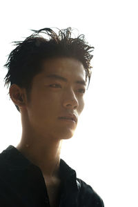 Portrait of young man looking away against white background