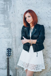 Portrait of woman standing against wall