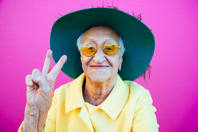 Portrait of woman against pink background